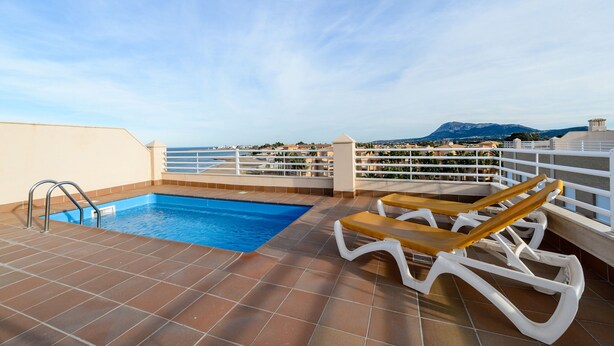 Una piscina sul tetto con vista sul mare e sulle montagne.