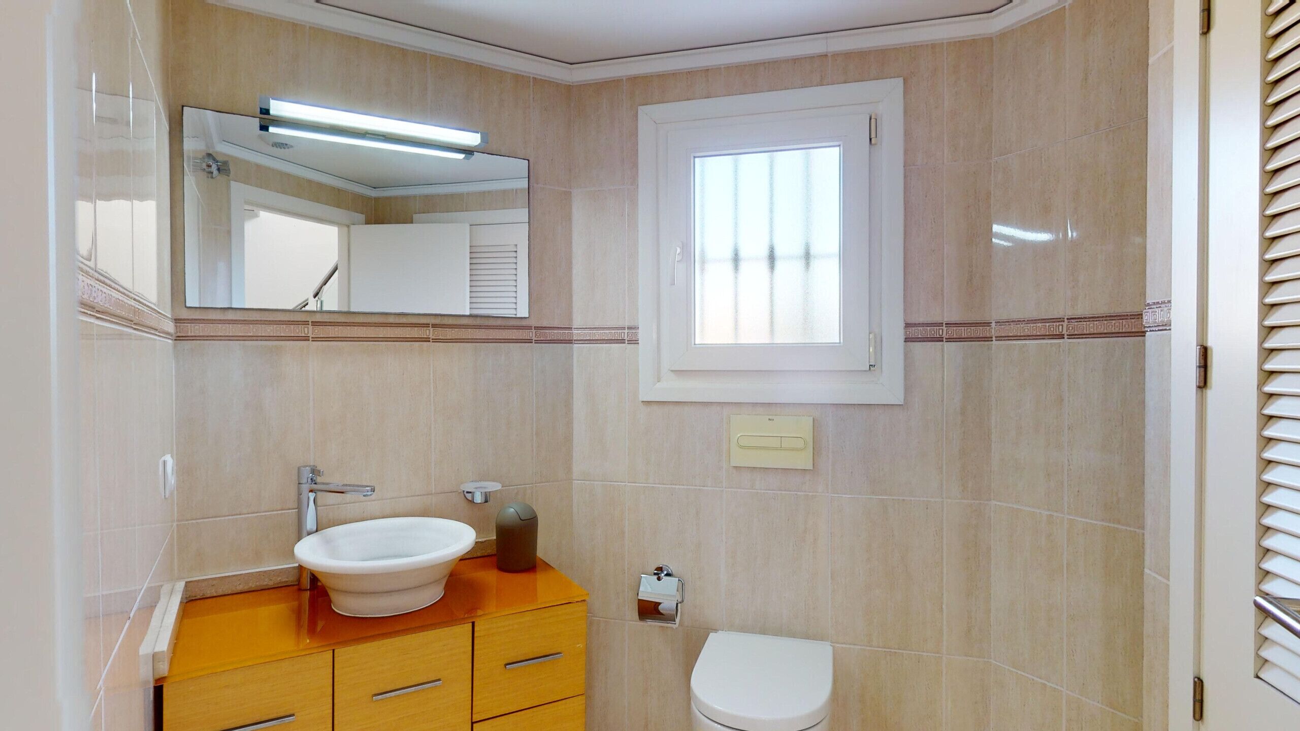 Ein Badezimmer mit Waschbecken, Spiegel und Toilette.