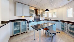 Una cocina moderna con una isla central, electrodomésticos integrados y mucho espacio de almacenamiento.