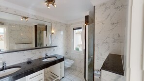 A bathroom with a large mirror, two sinks, a bidet, and a shower area. - Villa Golden by ON Travel (Oliva)
