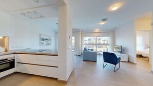 Een modern appartement met keuken, woonkamer en een balkon met uitzicht over de stad.