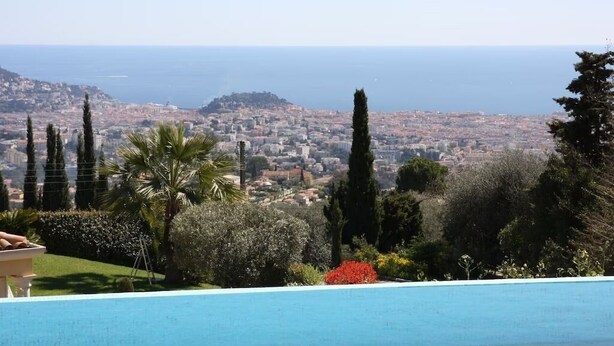 A swimming pool with a view of a coastal cityscape and hills. - Luxurious contemporary villa with magnificent sea view Nice, Alpes-Maritimes, France (Nice)