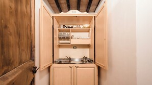 A compact kitchen with wooden cabinets, a sink, and a countertop. - Studio on organic farm located in ancient hamlet.  (Monterotondo Marittimo)