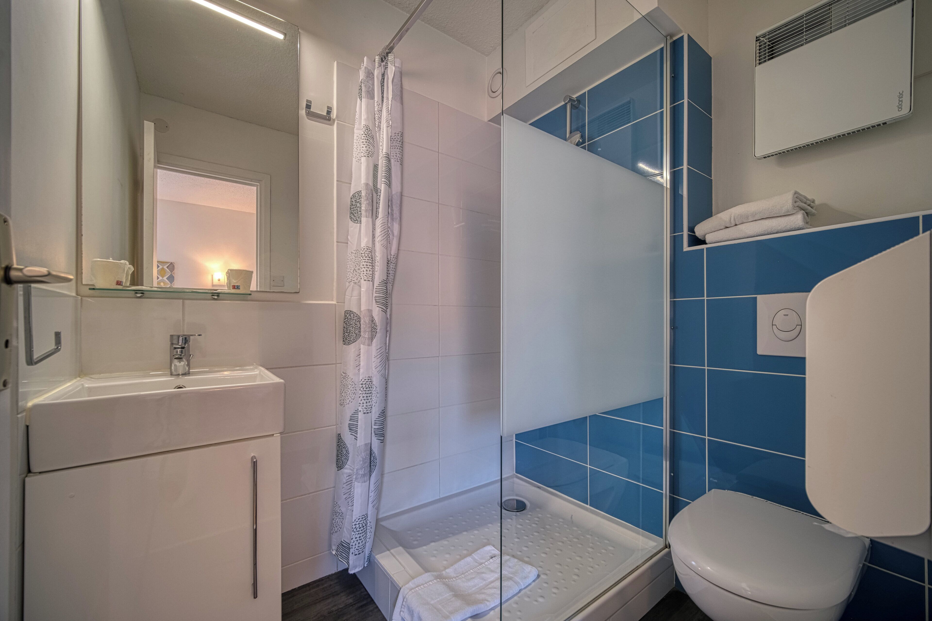 Ein Badezimmer mit Waschbecken, Duschkabine aus Glas und Toilette.