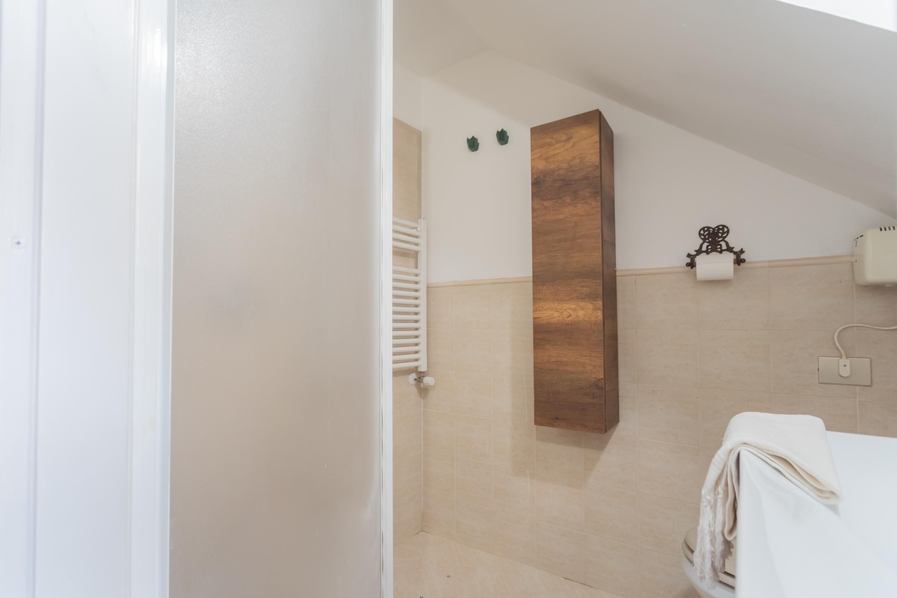 A bathroom with a wooden vanity, a towel rack, and a toilet.
