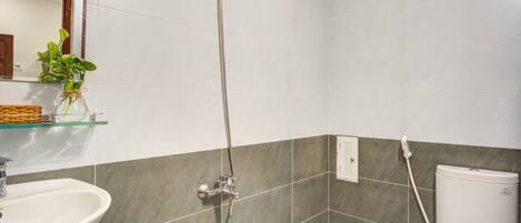 Un baño con ducha, lavamanos e inodoro.