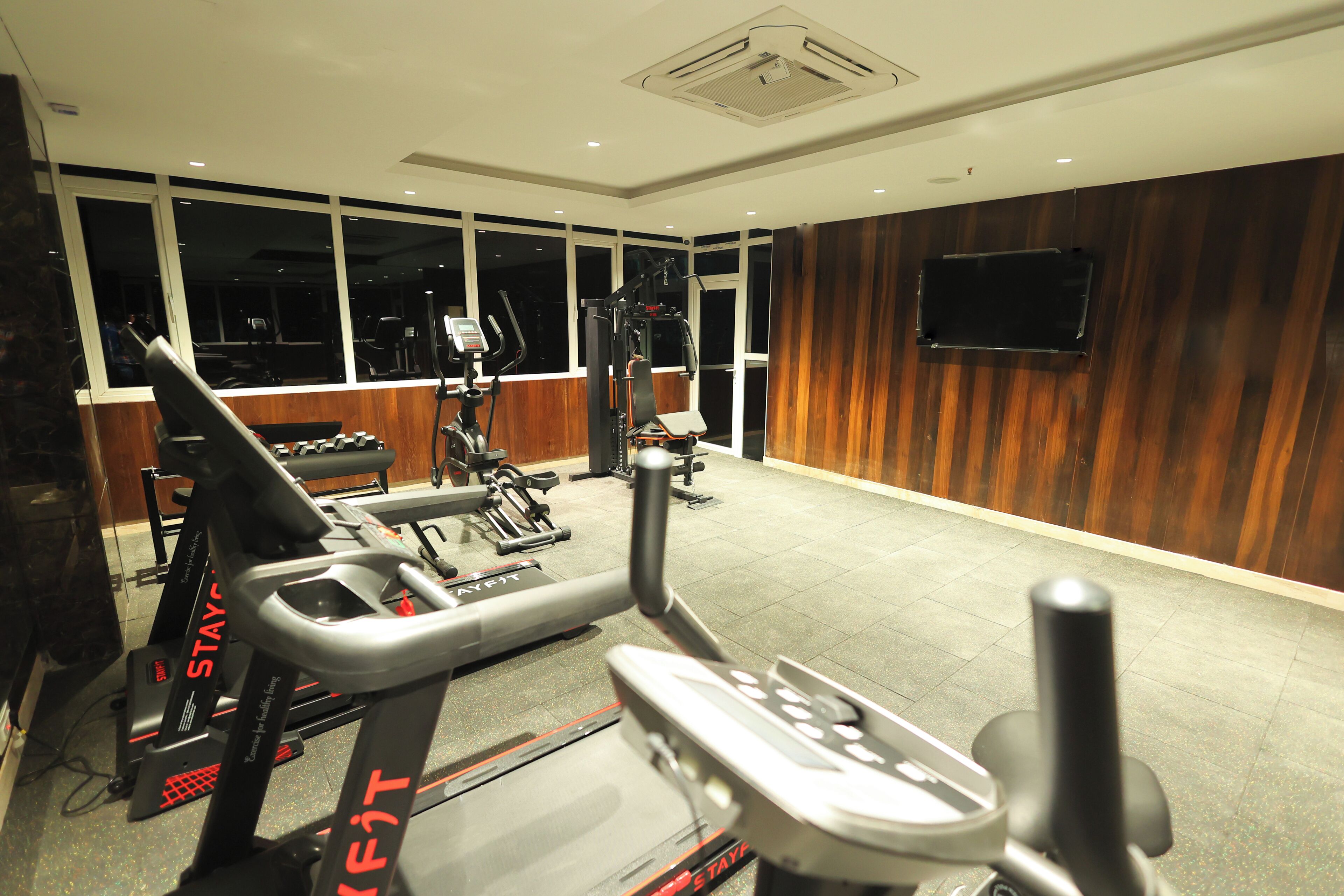 A gym with stationary bikes, a treadmill, and weight machines.