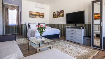 A modern hotel room with a bed, a TV, a dresser, and a large mirror.