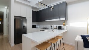 Eine moderne Küche mit einer großen Kochinsel, Edelstahlgeräten und einem minimalistischen Design.