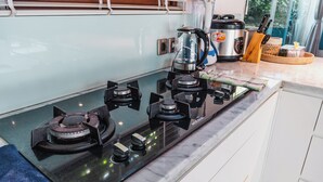 Una cocina moderna con estufa a gas, cafetera y cocedor de arroz.