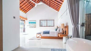 Un dormitorio moderno con una cama grande, una bañera y vistas al exterior.