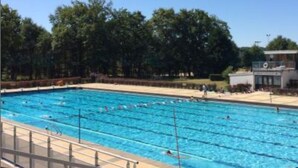 A swimming pool with multiple lanes, surrounded by trees and a small building. - Stylish Country House an hour from Paris (Chevrainvilliers)