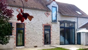 A house with a stone facade, a large glass door, and a small window. - Stylish Country House an hour from Paris (Chevrainvilliers)