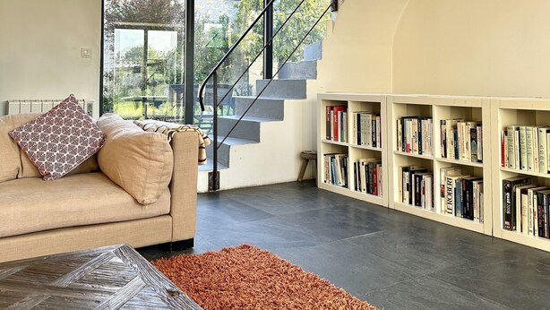 A modern living room with a sofa, a coffee table, and a bookshelf. - Stylish Country House an hour from Paris (Chevrainvilliers)