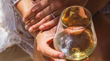 A close-up of hands holding a wine glass.