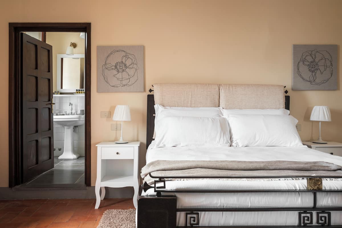 Une chambre à coucher avec un lit, des tables de chevet et des œuvres d’art murales.
