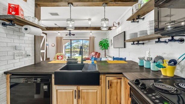 Une cuisine moderne dotée d’un îlot central, de meubles en bois et d’un lave-vaisselle encastré.