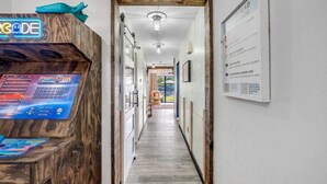 Un couloir avec un comptoir d’accueil en bois, sur lequel est installé un panneau lumineux et un tableau d’affichage contenant des informations de sécurité.