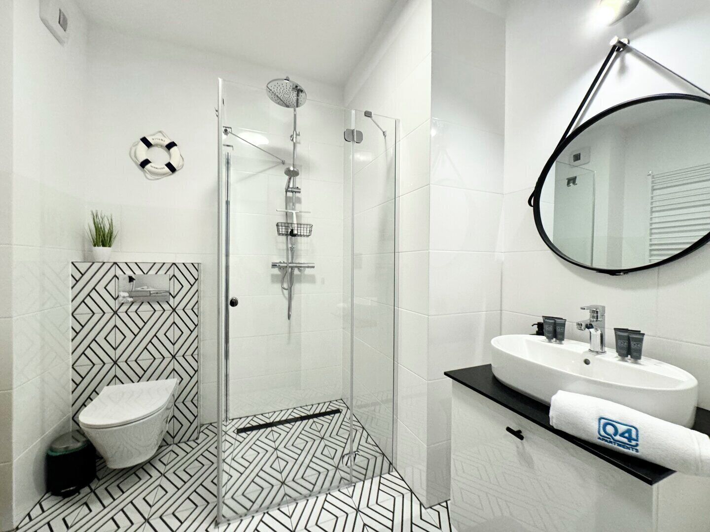 A modern bathroom with a shower, toilet, and sink.
