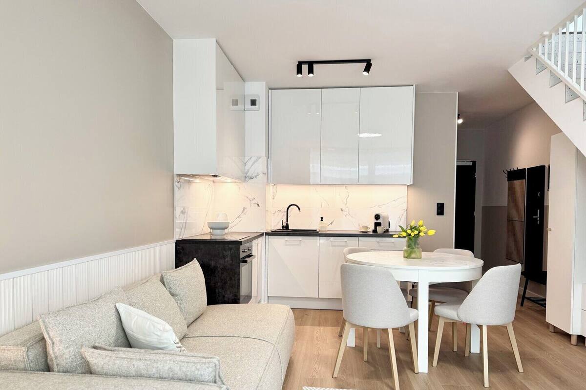 A modern apartment with a living room, kitchen, and dining area.