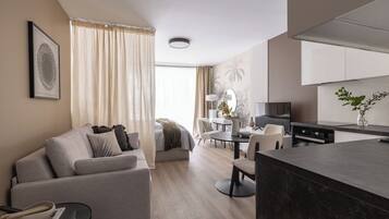Una sala de estar moderna con sofá, mesa de comedor y área de cocina.