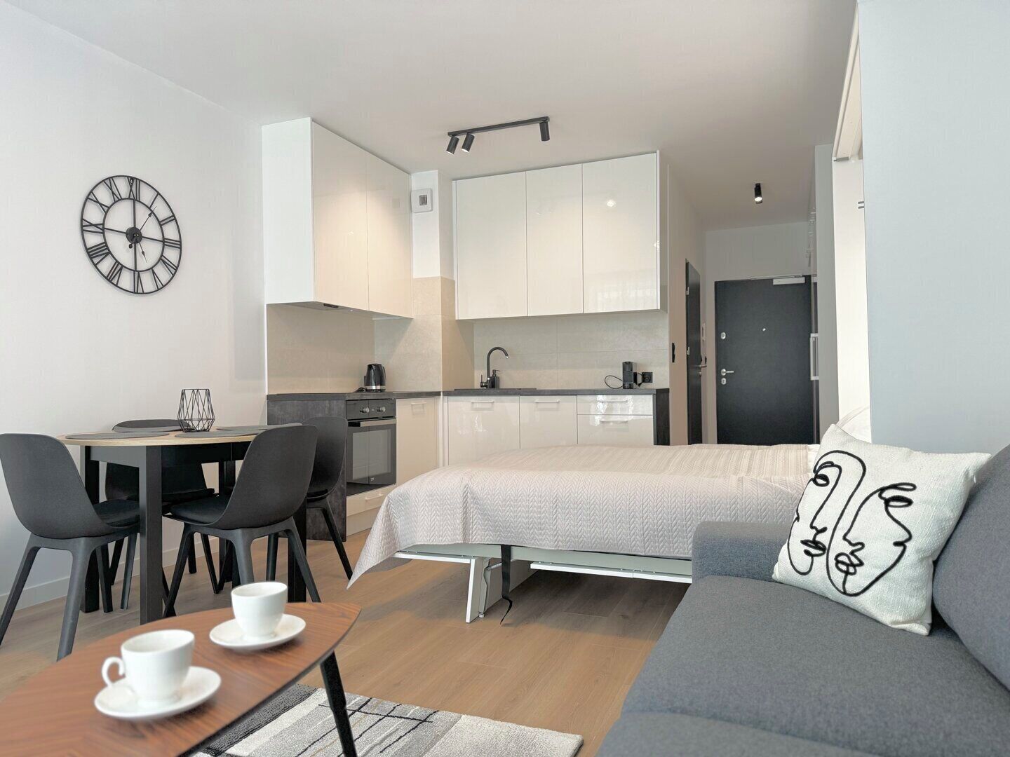 Un espacio habitable pequeño con kitchenette, comedor y cama.