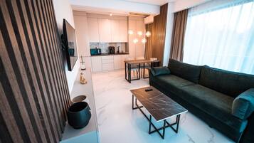Apartment, 1 Bedroom, Partial Sea View | Living area | 100-cm LED TV with cable channels, heated floors