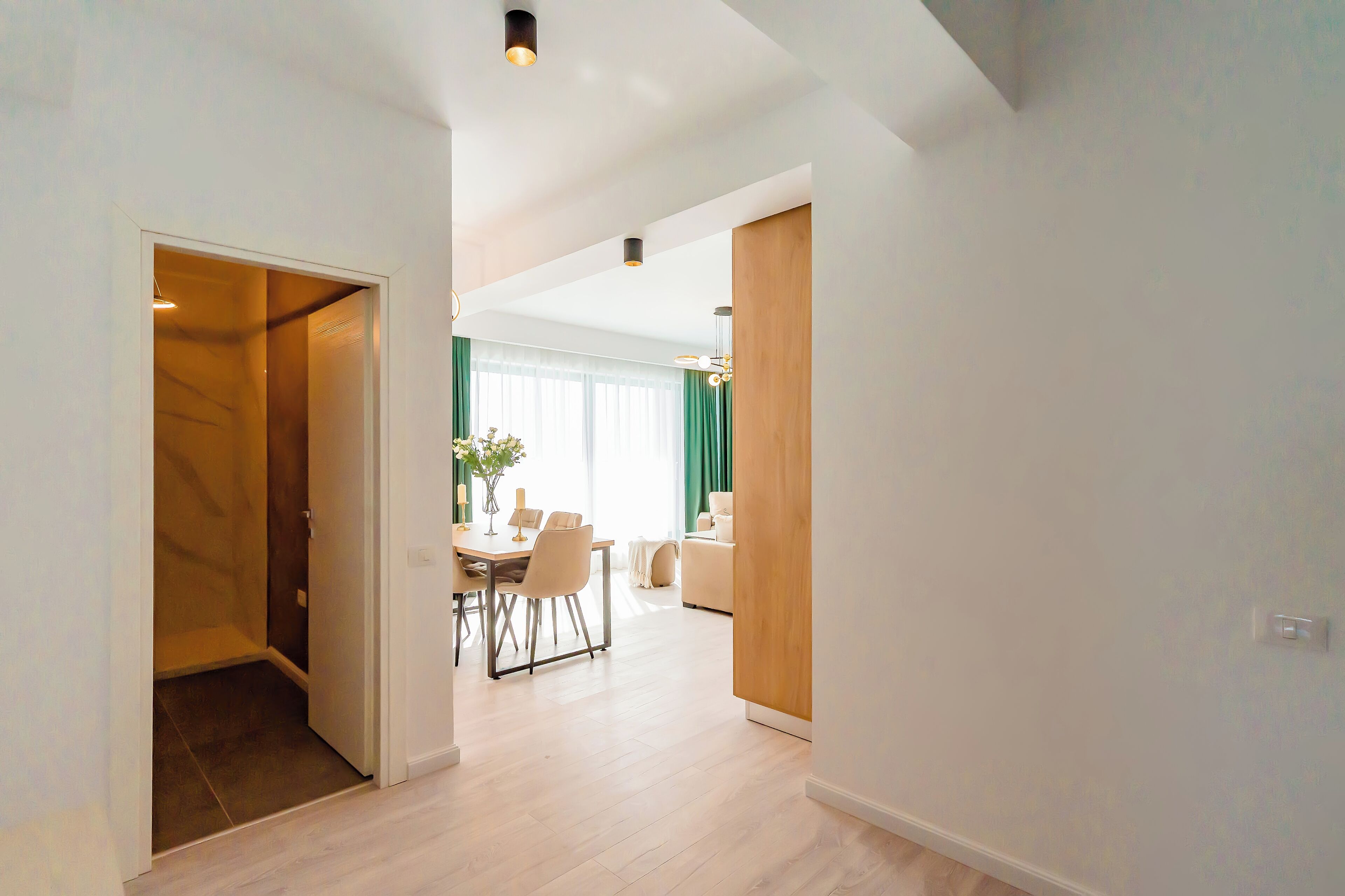 Un intérieur moderne comprenant un coin repas, un canapé et un mur d’accent en bois.