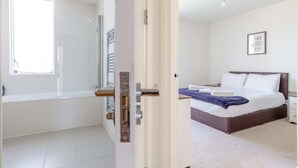 Une chambre à coucher avec un lit, une fenêtre et une salle de bain avec douche.