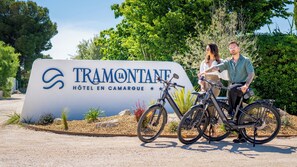 A sign for Tramontane Hotel in Camargue with two bicycles parked in front. - Hôtel La Tramontane (Saintes-Maries-de-la-Mer)