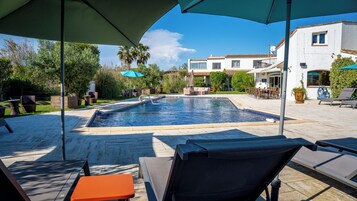 Una piscina al aire libre de temporada, sombrillas