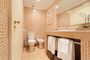 A bathroom with a toilet, bidet, and sink, tiled in a warm color scheme. - 2 bedroom next to Avenida da Liberdade (Lisboa)