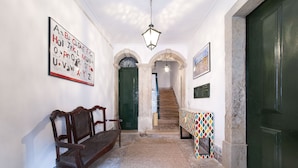 Ein Flur mit einer hölzernen Bank, einem Tisch mit Muster und einer Treppe zu einem anderen Raum.