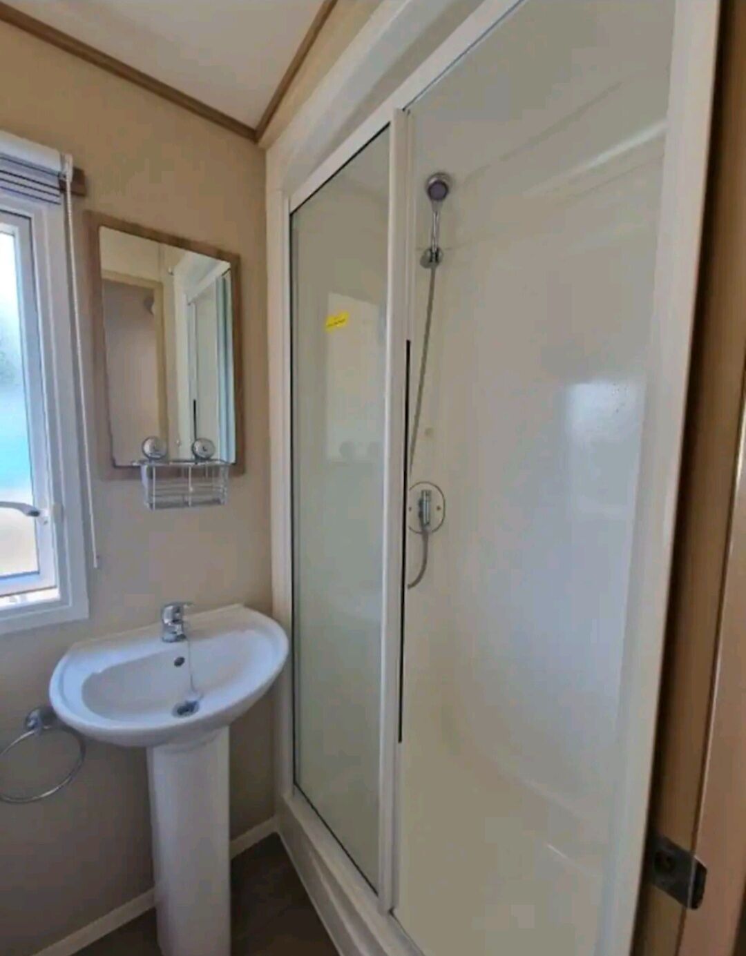 Une salle de bain avec une douche à parois de verre, un lavabo et un miroir.