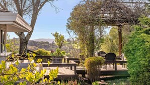A wooden deck with outdoor furniture, a pergola, and a view of the landscape. - Gorgeous Pool and Sweeping Views (Sonoma)