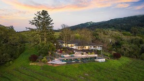 A large house with a swimming pool and a vineyard in the foreground. - Gorgeous Pool and Sweeping Views (Sonoma)