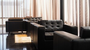 Et moderne loungeområde med lædersofaer og en marmorgulv.