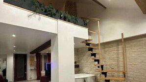 Un espace de vie moderne comprenant un escalier, un coin repas et une cuisine.