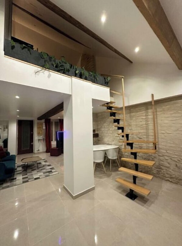 Un espace de vie moderne comprenant un escalier, un coin repas et une cuisine.