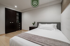 A bedroom with a bed, a nightstand, a dresser, and a closet. - Vita Polanco by Naya Homes (Mexico City)