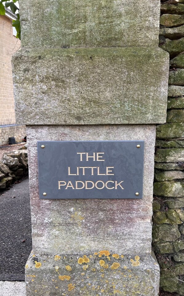 Een stenen plaquette met de inscriptie 'The Little Paddock' bevestigd aan een stenen muur.