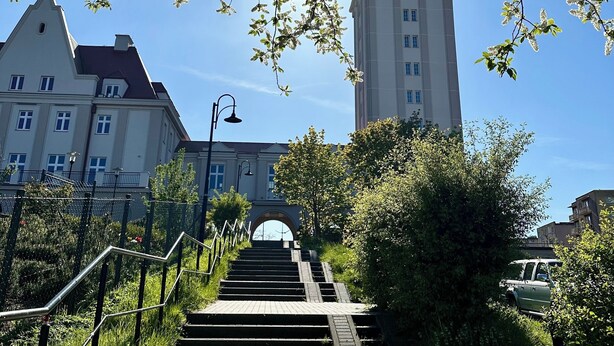 A pathway leading to a building with a tower, surrounded by trees and a clear sky. - Apartament Suzanne by Q4Apartments  (Wladyslawowo)