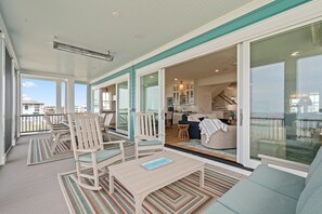 Un grand balcon doté d’un espace repas, de sièges et offrant une vue sur les environs.