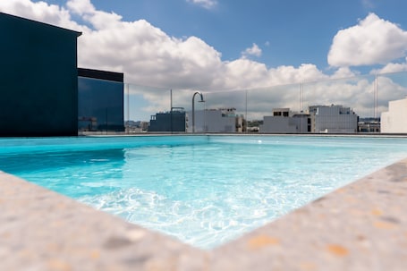 Una piscina al aire libre, sillones reclinables de piscina