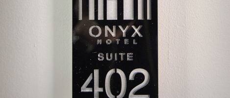 A hotel sign with the name "ONYX HOTEL SUITE 402" in a modern, geometric design.