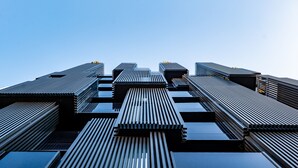 Ein modernes Gebäude mit einem einzigartigen, winkelförmigen Design, das mehrere Ebenen und eine Reihe vertikaler und horizontaler Linien aufweist.
