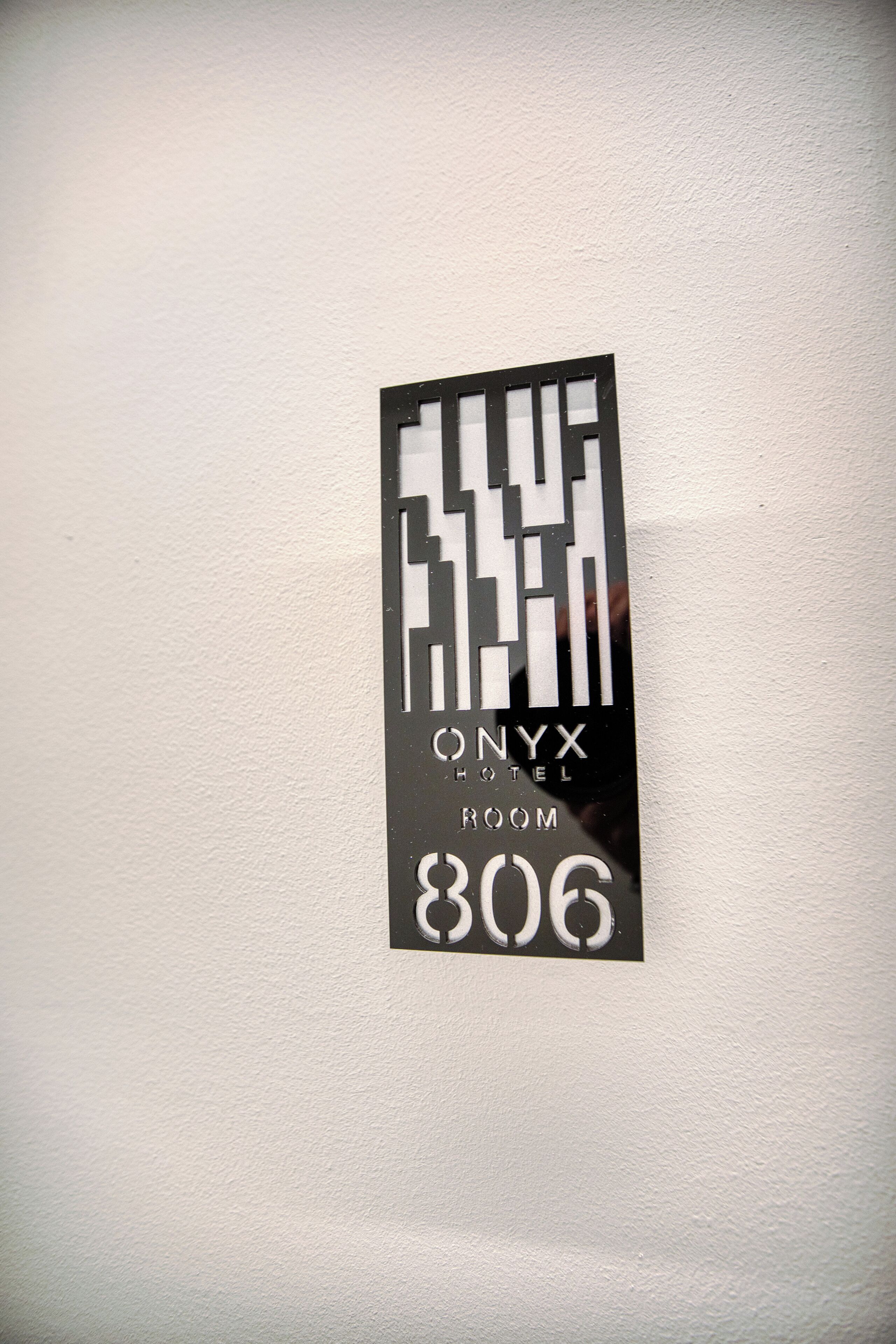 A hotel room sign with the name "ONYX HOTEL" and room number "806".