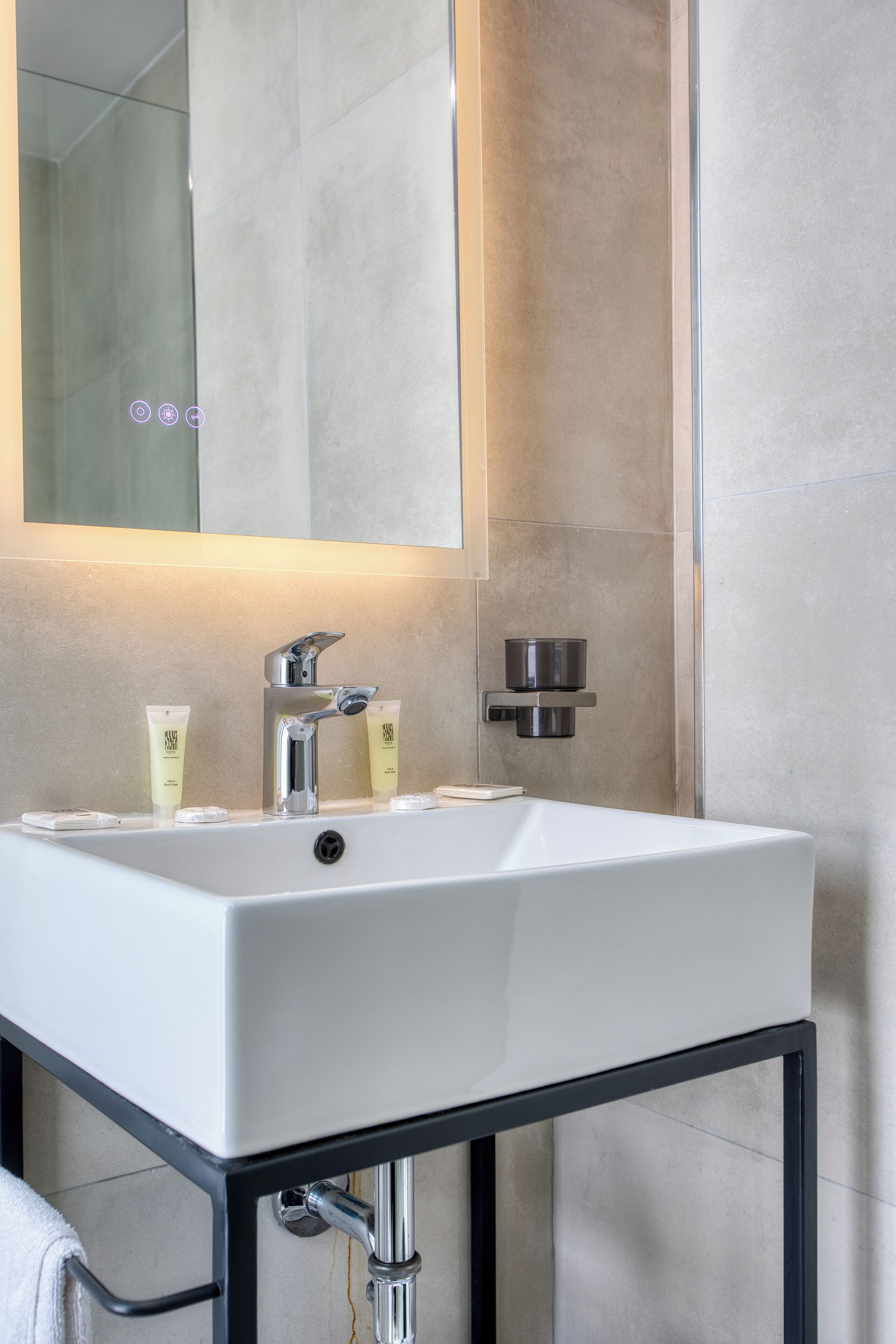 Une salle de bain moderne avec un lavabo blanc, un robinet chromé et un miroir au-dessus.