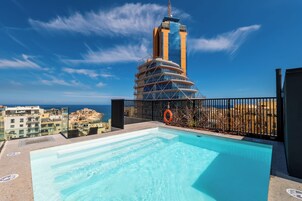 Una piscina al aire libre, sillones reclinables de piscina