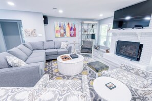 Una Smart TV, una chimenea, libros, una biblioteca de música